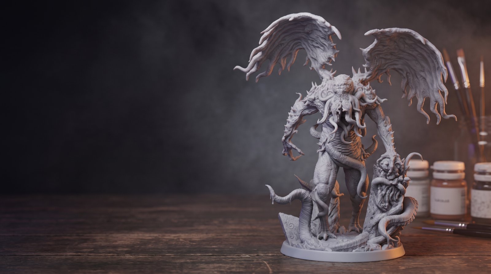 Szara figurka Cthulhu z żywicy w półmroku na stole warsztatowym